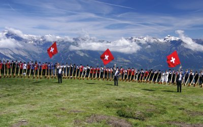 Alphornparade mit Schweizer Fahnenschwinger © Bergfee-fotolia.com